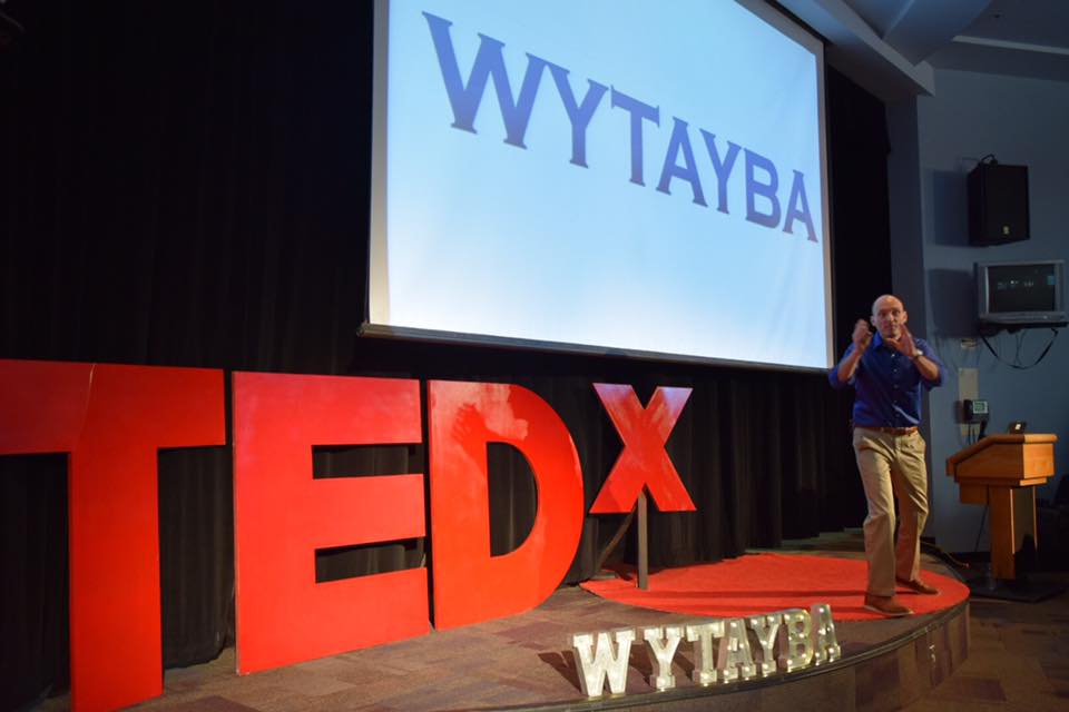 Blaine Oelkers on stage at his TEDx talk on his concept of WYTAYBA